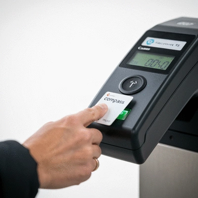 Person tapping a Compass Card on a public transit reader in Vancouver